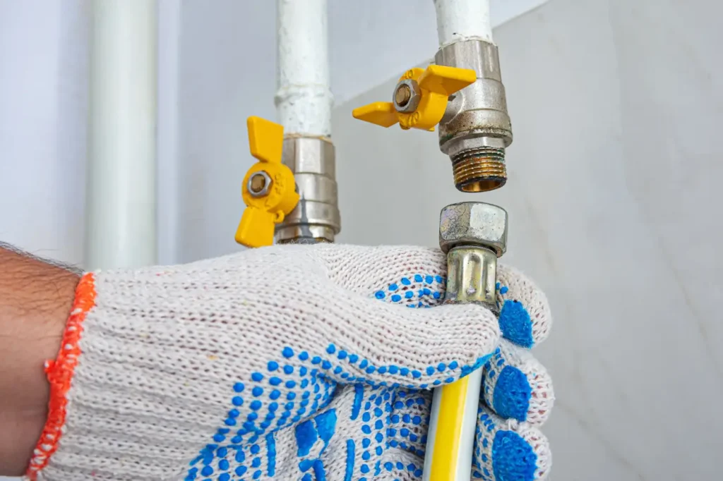 Plumber connecting a gas line fitting for Taylor Plumbing South Auckland showing careful gas fitting and repair work
