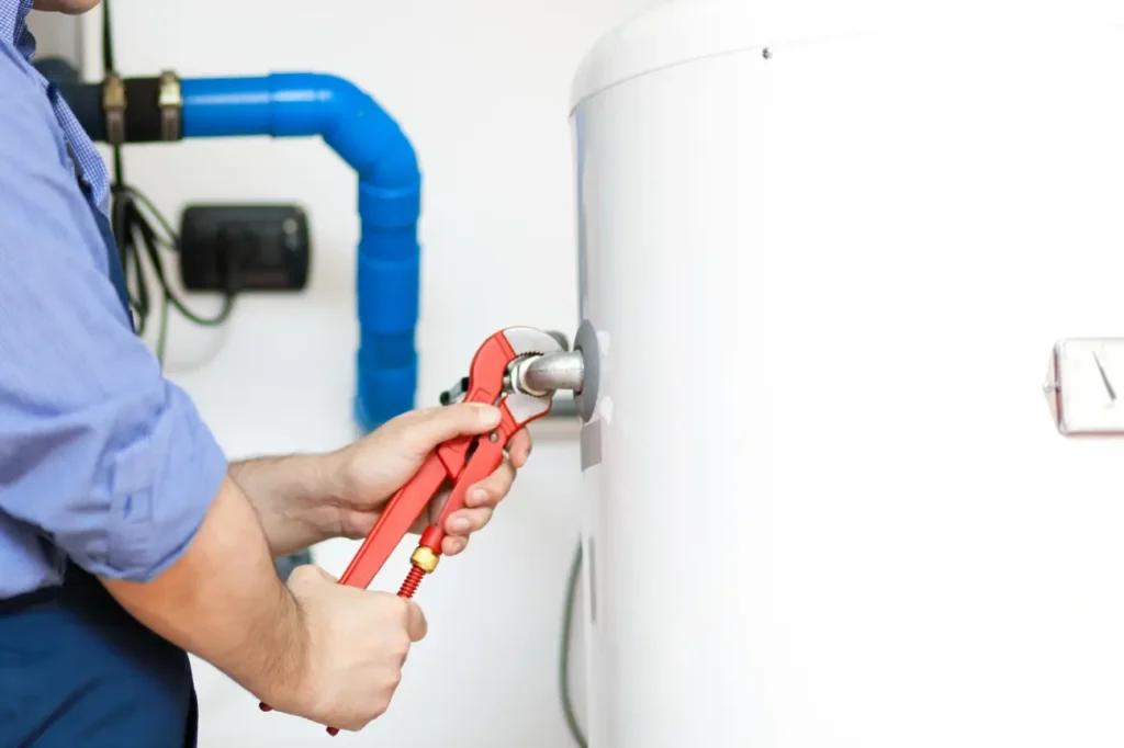 Plumber adjusting a hot water system pipe for Taylor Plumbing South Auckland showing expert hot water repair service